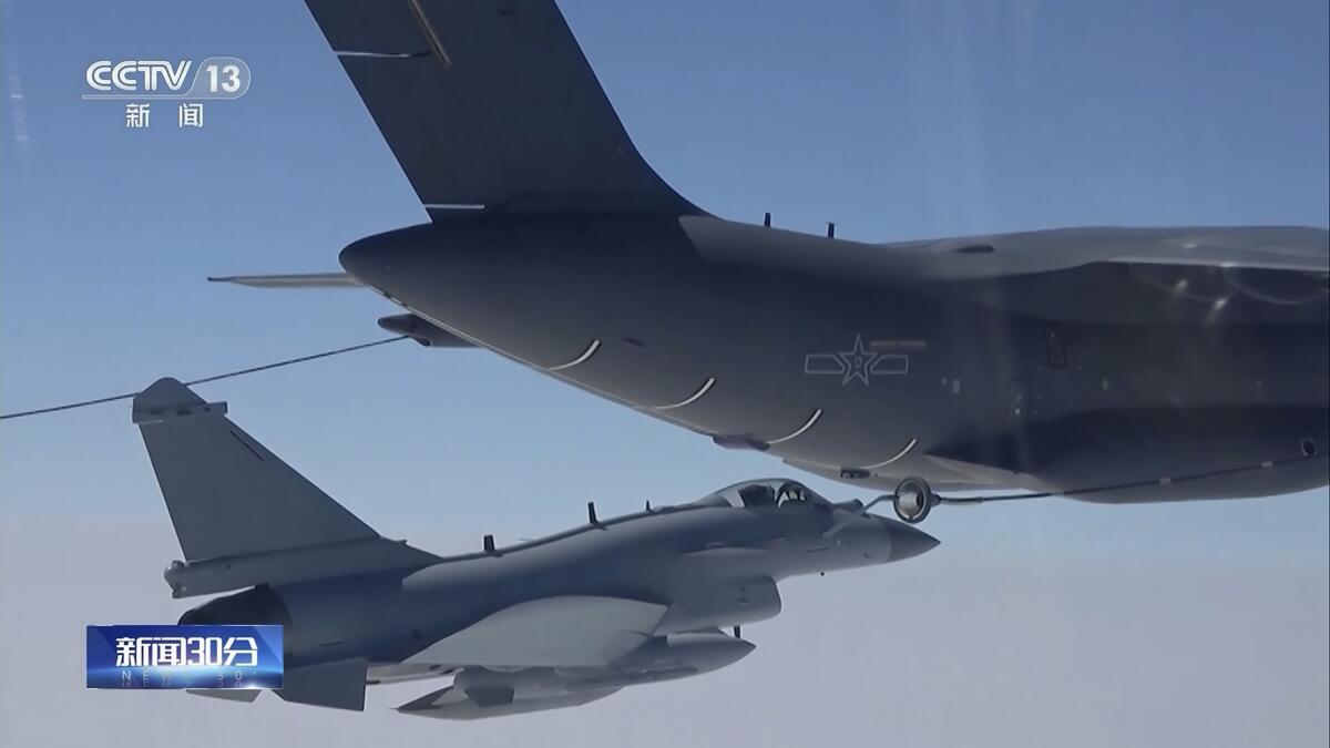 An image taken from video shows Chinese fighter jets performing a midair refueling maneuver.