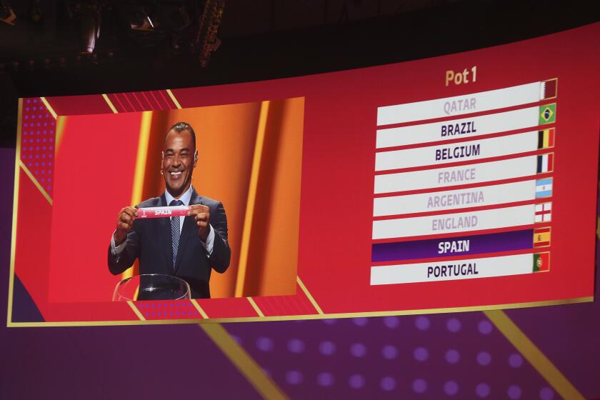 Former Brazilian soccer international Cafu holds up the name of Spain during the 2022 soccer World Cup draw at the Doha Exhibition and Convention Center in Doha, Qatar, Friday, April 1, 2022. (AP Photo/Hussein Sayed)