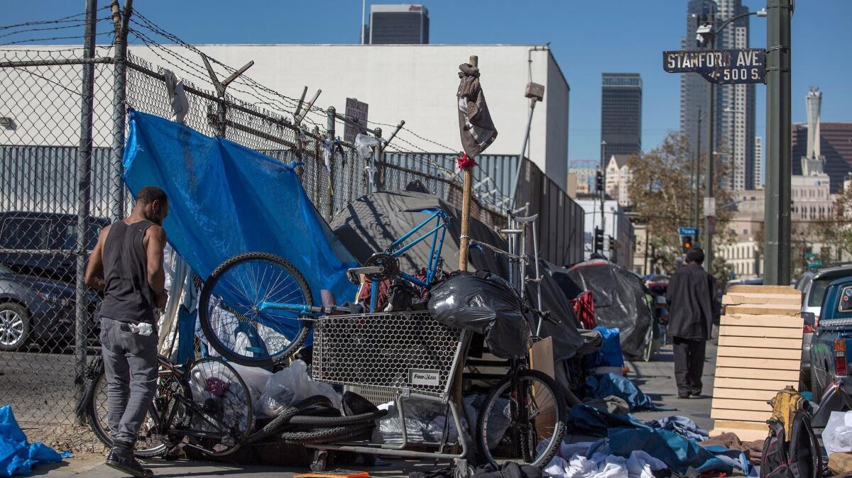 The homeless gather around tents along 5th Street and Stanford Avenue on skid row in Los Angeles this month.