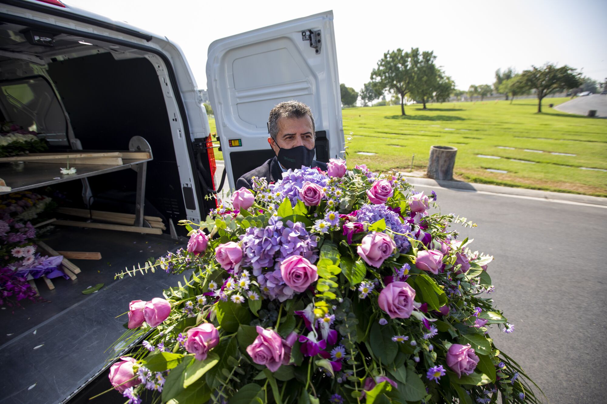 Trino Jimenez delivers flowers for a funeral service at Resurrection Cemetery in Rosemead