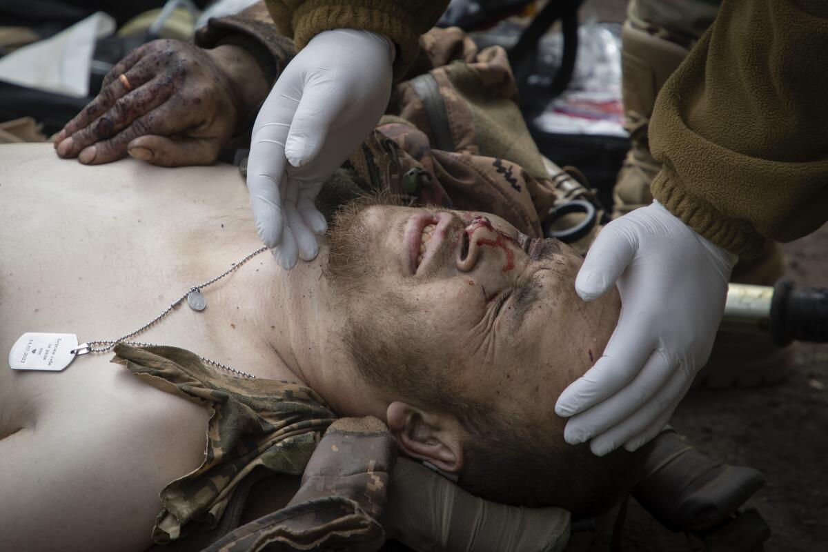 A military medic give first aid to a wounded soldier.