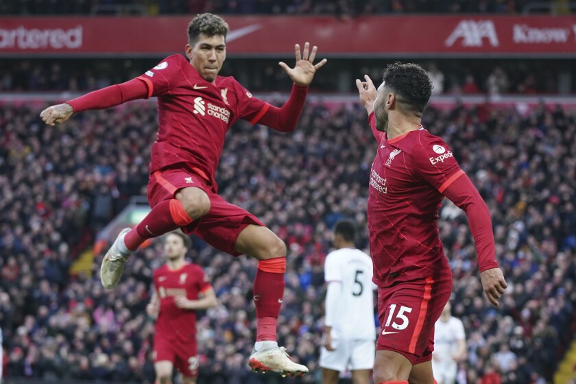 Liverpool's Alex Oxlade-Chamberlain, right, celebrates with Liverpool's Roberto Firmino after scoring his side's second goal during an English Premier League soccer match between Liverpool and Brentford at Anfield in Liverpool, England, Sunday, Jan. 16, 2022. (AP Photo/Jon Super)