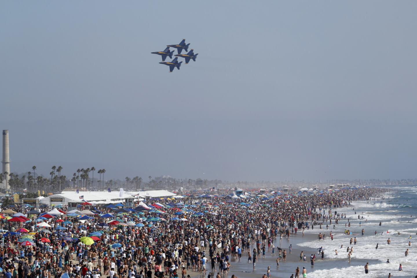 A large crowd lines the shore as the U.S. Navy Blue Angels fly in formation in the second annual Breitling Huntington Beach Air Show, which also featured the Royal Canadian Air Force Snowbirds, a FedEx 757 flyby and other performances.