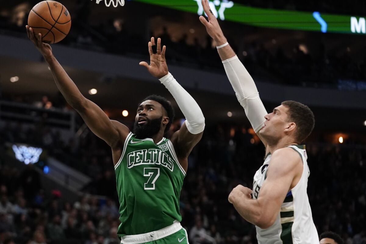 Boston Celtics' Jaylen Brown shoots past Milwaukee Bucks' Brook Lopez during the second half of an NBA basketball game Thursday, April 7, 2022, in Milwaukee. The Bucks won 127-121. (AP Photo/Morry Gash)