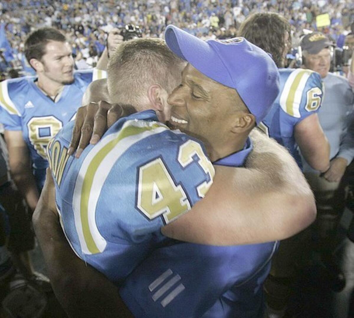 UCLA Coach Karl Dorrell celebrates after the victory with Danny Nelson.