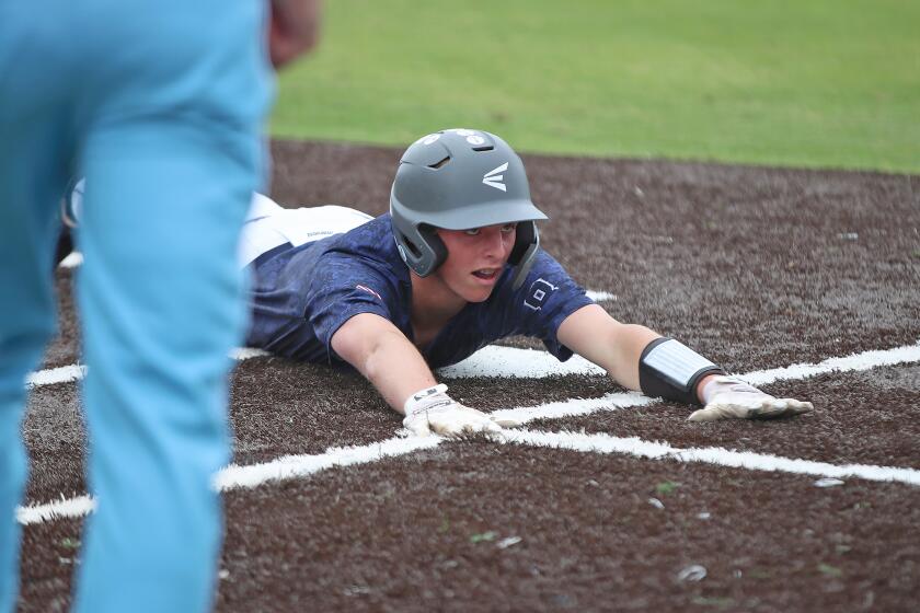 Newport Harbor's Gavin Guy slides into home tying the score 1-1 during Battle of the Bay rival baseball game against Corona del Mar on Friday.