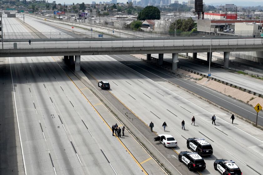 Monterey Park, CA - March 31: Police investigators line I-10 Freeway to look for evidence after police fatally shot a suspect (driving the white car) who apparently bailed out of a vehicle and ran across the San Bernardino (10) Freeway in the City Terrace area today, prompting a full closure of the highway and causing extensive backups in both directions. Photo taken in Monterey Park Friday, March 31, 2023. The shooting occurred late Friday morning on the 10 Freeway just east of the Long Beach (710) Freeway. The California Highway Patrol initially announced that all eastbound lanes of the freeway were closed at Eastern Avenue, but the westbound side of the heavily traveled freeway was also shut down to accommodate the investigation.(Allen J. Schaben / Los Angeles Times)