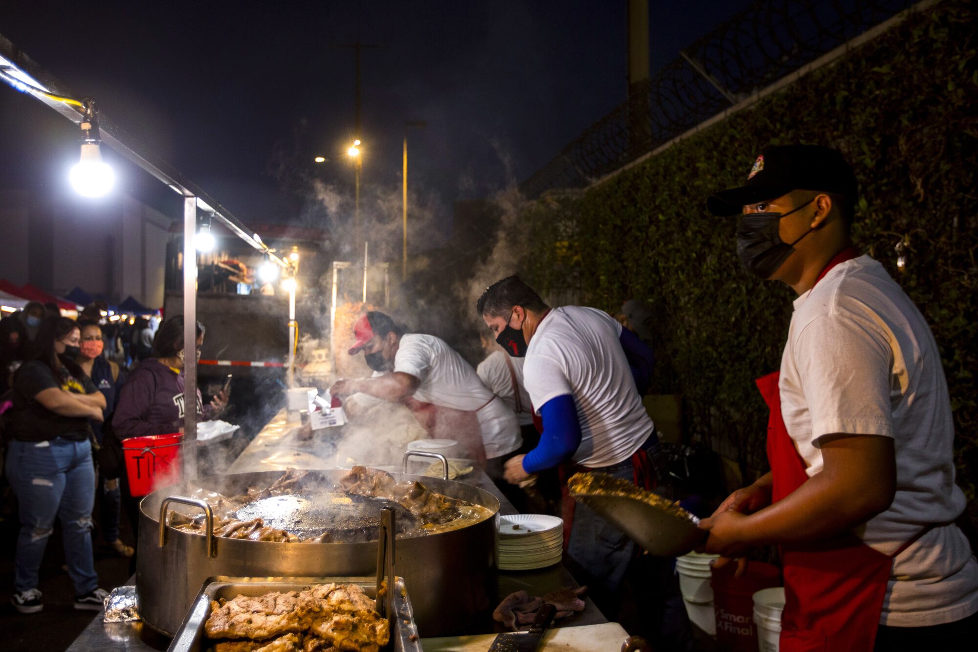 Customers stand in line for tacos
