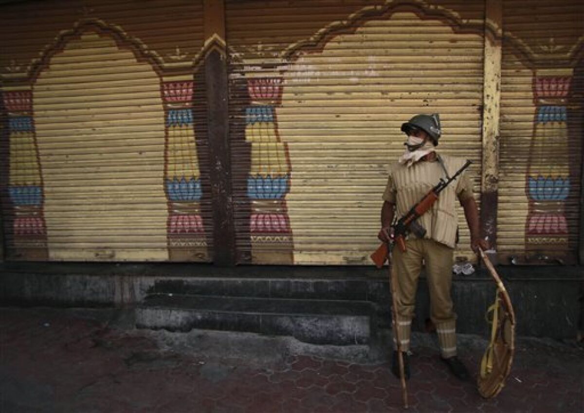 An Indian paramilitary soldier stands guard, ahead of a potentially explosive court verdict on whether Hindus or Muslims should control a disputed holy site in Ayodhya, in Jammu, India, Thursday, Sept. 30, 2010. Police have arrested more than 10,000 people to prevent them from inciting violence, while another 100,000 had to sign affidavits saying they would not cause trouble after the verdict, a top official said. The 16th-century Babri Mosque, Hindus claim was erected at the birthplace of their god Rama, stood at the disputed site in the town of Ayodhya before it was razed by Hindu hard-liners in 1992, setting off violence that killed 2,000 nationwide. (AP Photo/Channi Anand)