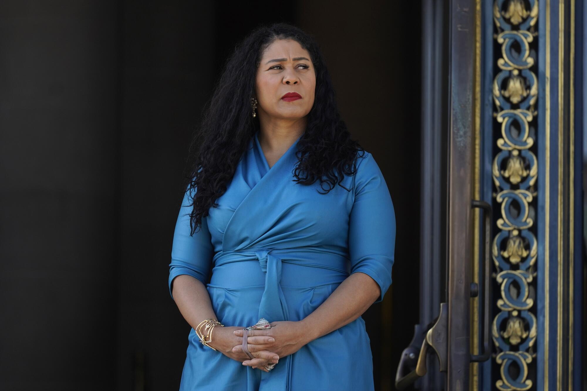 San Francisco Mayor London Breed listens during a briefing outside City Hall.