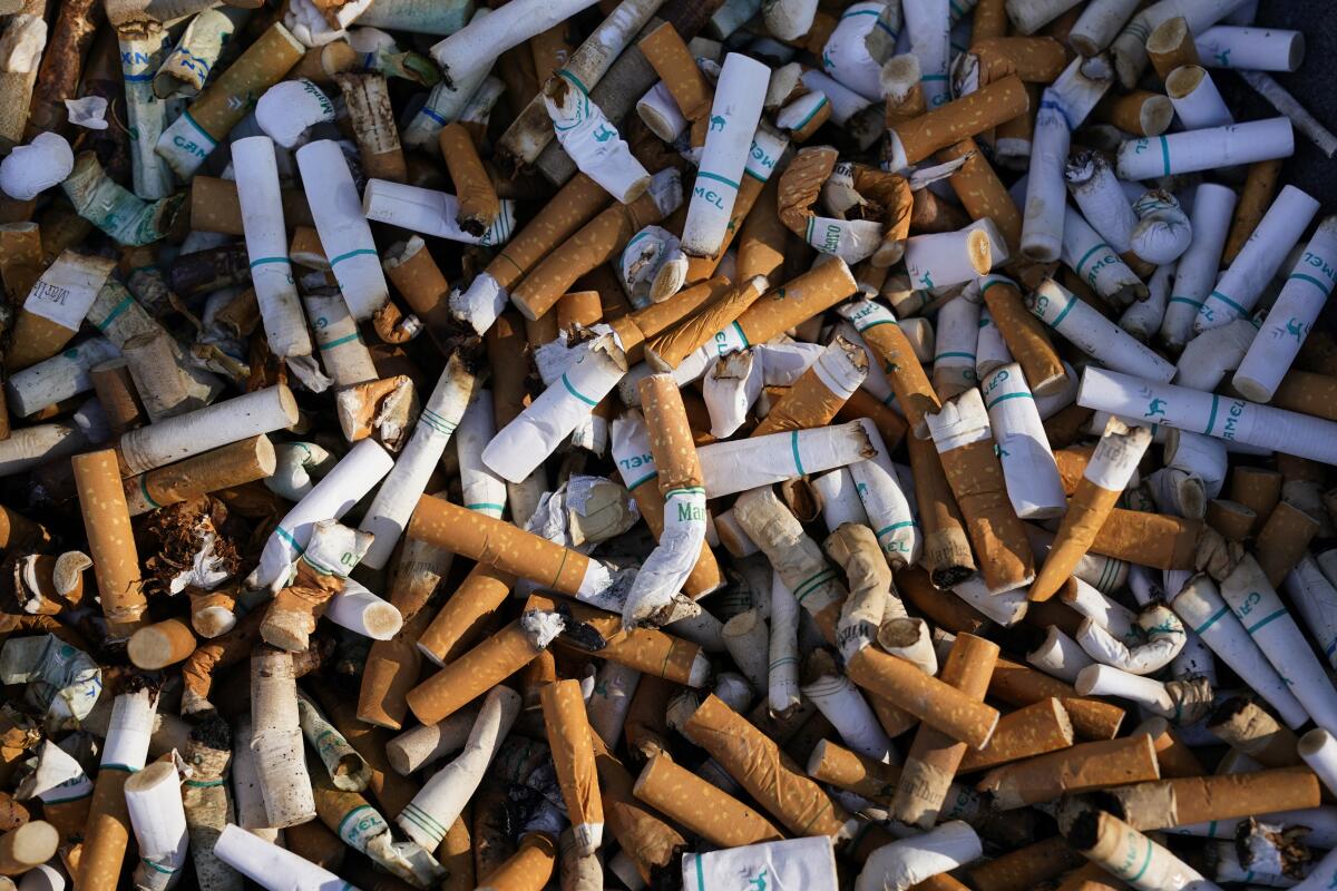 ARCHIVO - Restos de cigarrillos llenan un recipiente ante un edificio federal en Washington