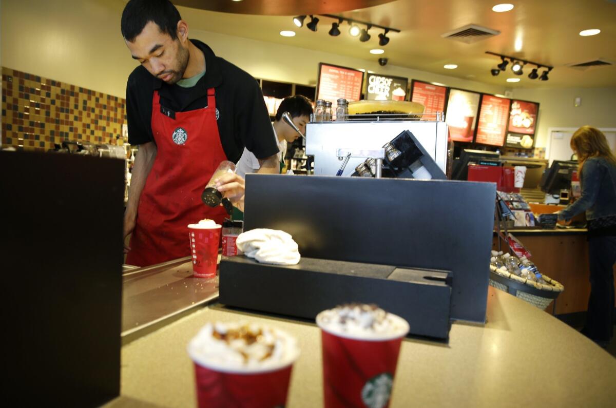 Jay Rapp prepares a chestnut praline latte at a Starbucks store in Seattle. On Monday, Starbucks said it will offer its employees four years of tuition-free online education through Arizona State University.