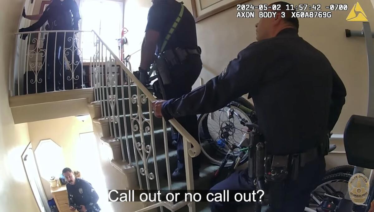 Body-cam image of police officers ascending an interior staircase