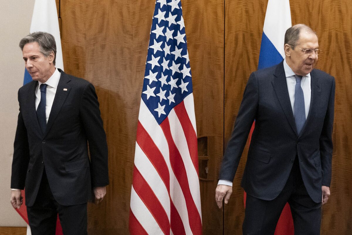 Antony Blinken and Sergei Lavrov move away from each other, toward their seats, before meeting in Geneva.