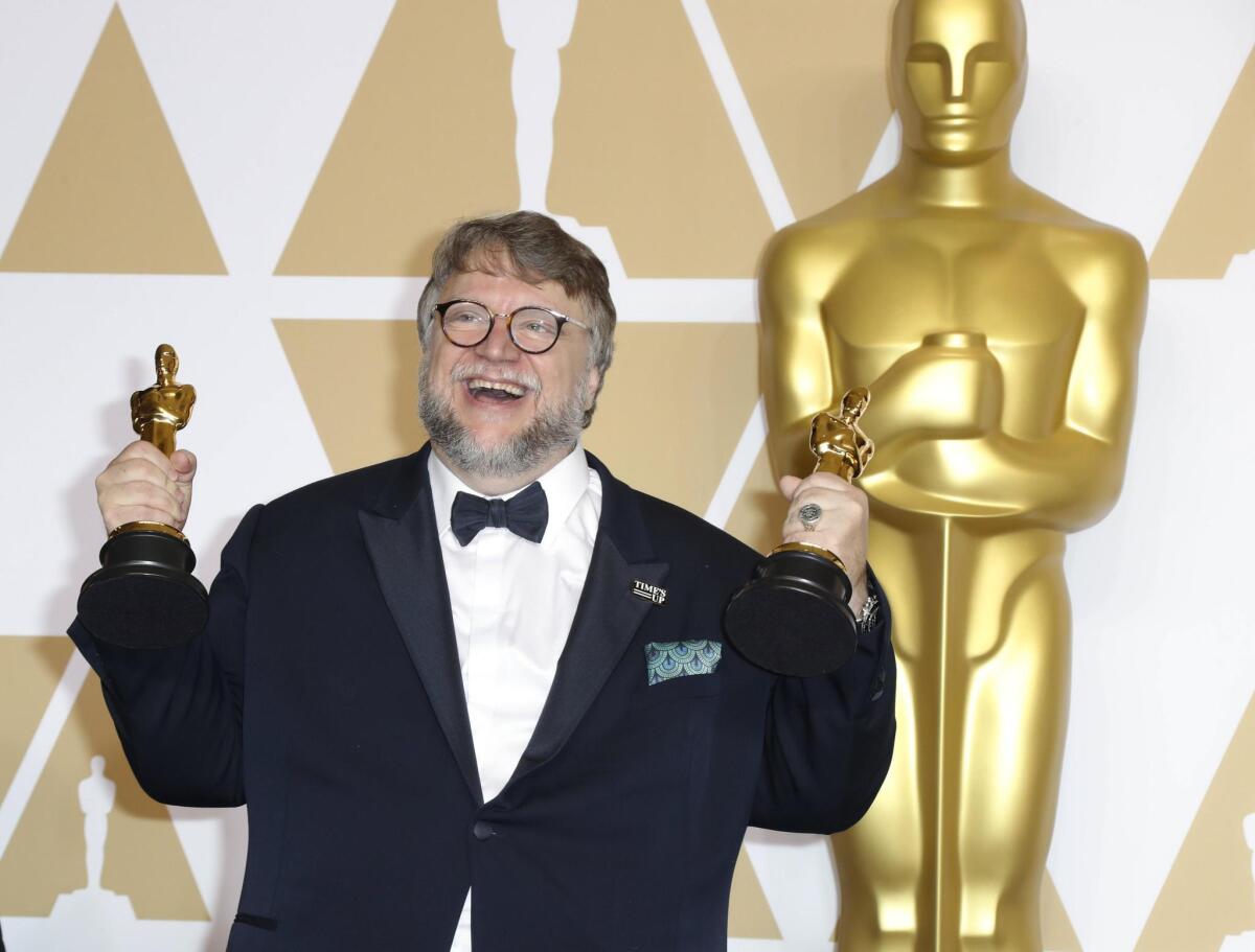 Guillermo del Toro posa con las dos estatuillas que lo consagraron como el cineasta más celebrado en la edición número 90 del Oscar.