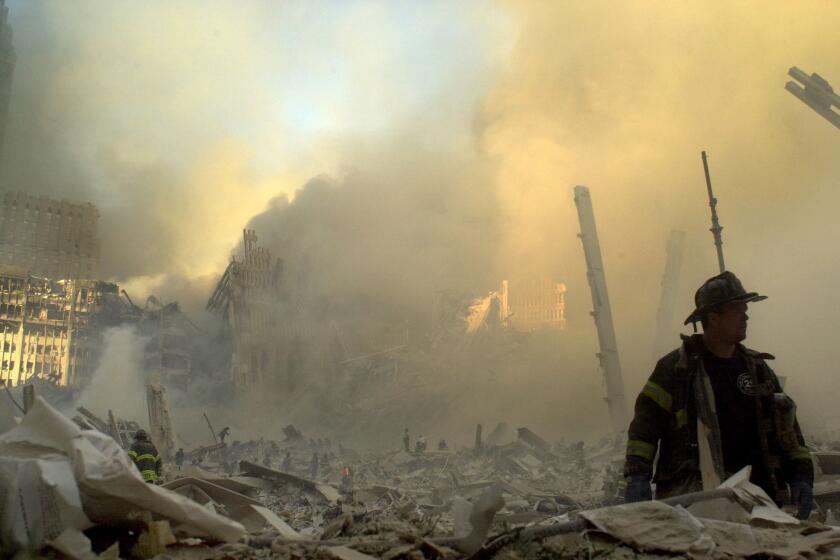 A firefighter moves through piles of debris at the site of the World Trade Center on Sept. 11, 2001.