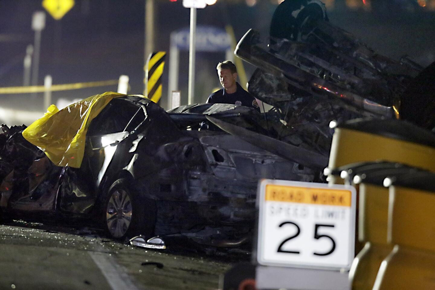 An official examines the charred wreckage after a fatal three-car crash in Chino.