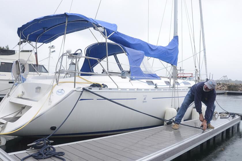 Rick Ellerbrook double checks the lines his sailboat moored in Sydney, Nova Scotia, late Friday, Sept. 23, 2022. Hurricane Fiona is poised to become a "very powerful" post-tropical storm by the time it makes landfall in eastern Nova Scotia this weekend, forecasters said Friday. (Vaughan Merchant/The Canadian Press via AP)