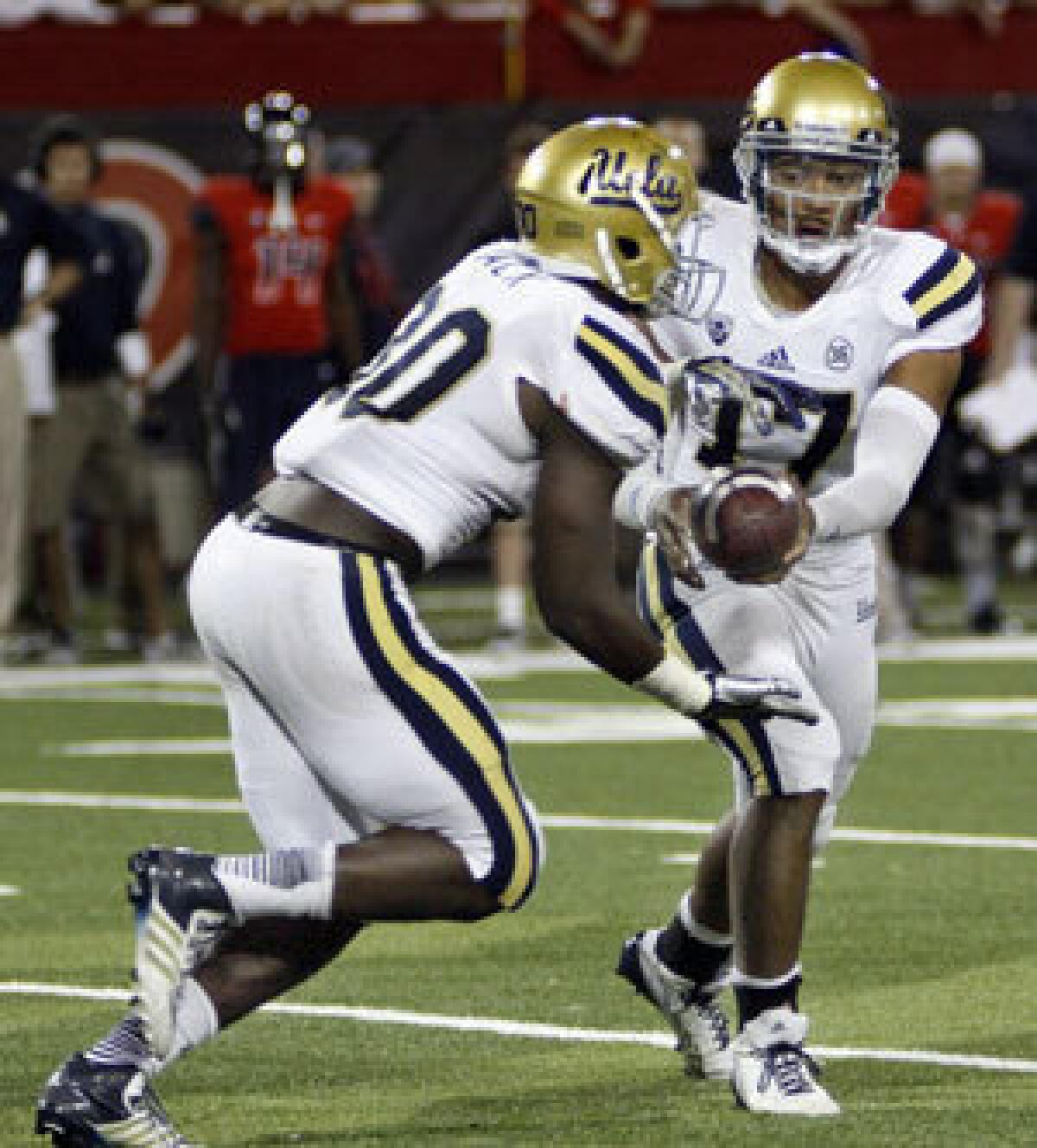 Myles Jack takes a handoff from UCLA quarterback Brett Hundley against Arizona.