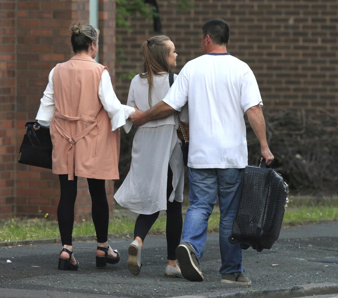 A fan leaves a hotel with her parents May 23, 2017, in Manchester, England, a day after a suicide bomber attacked at an Ariana Grande concert at Manchester Arena.