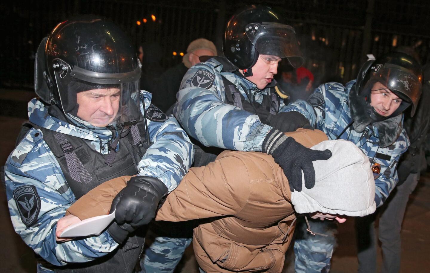 Police officers detain a supporter of opposition leader and anti-corruption blogger Alexei Navalny during a rally in central Moscow.