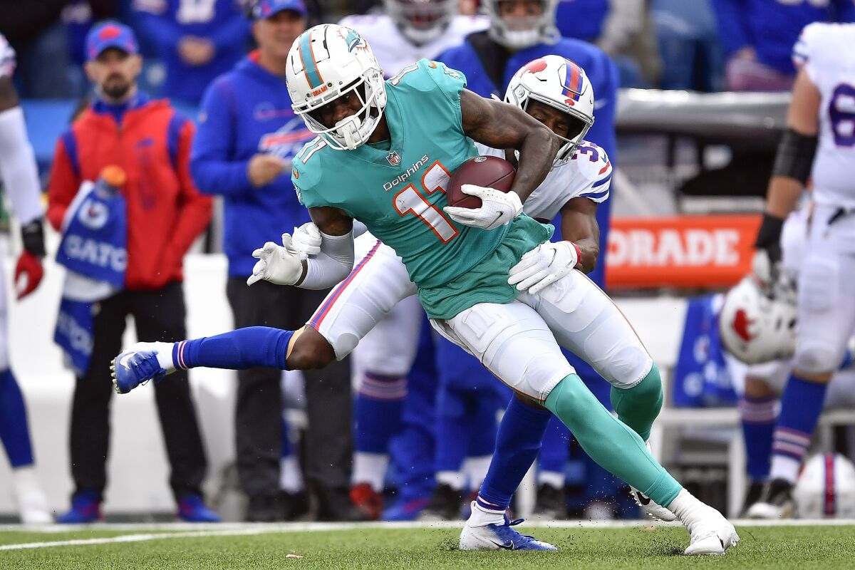 FILE - Miami Dolphins wide receiver DeVante Parker, front, breaks a tackle by Buffalo Bills cornerback Levi Wallace during the first half of an NFL football game, on Oct. 31, 2021, in Orchard Park, N.Y. The Patriots looked within their division to find some help at receiver, completing a trade with the Dolphins on Tuesday, April 5, 2022, to acquire veteran DeVante Parker. (AP Photo/Adrian Kraus, File)