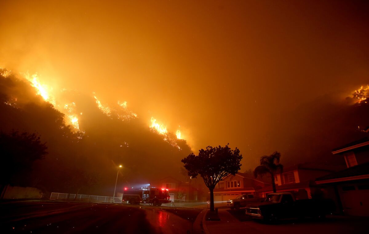 Fast-moving flames from the Canyon fire threaten a neighborhood in Corona on Monday evening.