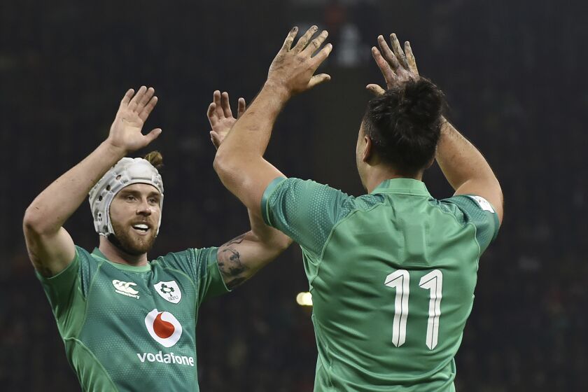 Ireland's James Lowe, right, celebrates with teammate Mack Hansen after scoring a try during the Six Nations rugby union international match between Wales and Ireland at the Principality Stadium in Cardiff, Wales, Saturday, Feb. 4, 2023. (AP Photo/Rui Vieira)