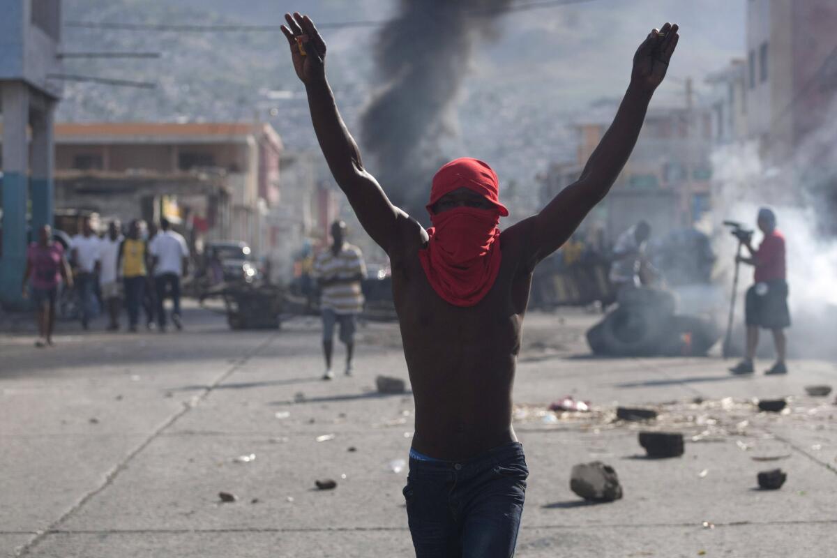 A masked protester participates in a demonstration Sunday in Port-au-Prince, Haiti, demanding the resignation of President Michel Martelly.