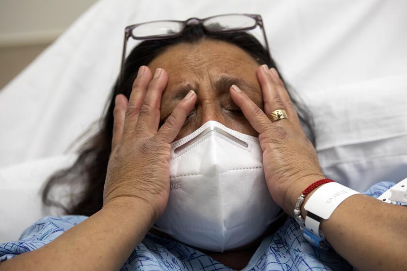 ORANGE, CA - FEBRUARY 22: Maria Mandujanu, 53, of Santa Ana begins to cry in the emergency department at Providence St. Joseph Hospital on Monday, Feb. 22, 2021 in Orange, CA. She was recently diagnosed with covid. Neurologist and chief of staff Dr. Brian Boyd is talking with her about her goals of care. Providence has started this program they call "Goals of Care" and that they characterize as "palliative care meets the ED," a pop-up service for the sickest COVID patients coming in through the emergency room. (Francine Orr / Los Angeles Times)