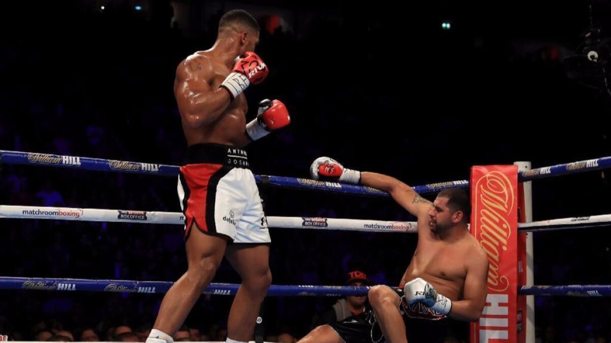 Anthony Joshua knocks down Eric Molina during their IBF world heavyweight championship fight on Dec. 10 in Manchester, England.