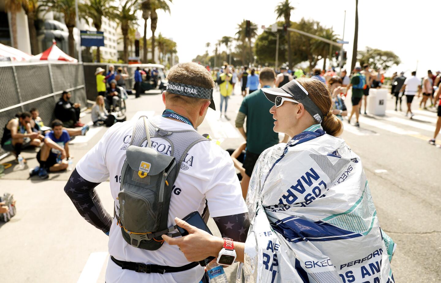 Michael Bangora, left, and his wife Stephanie, of Canyon Lake, walk off together after finishing the L.A. Marathon on Sunday.