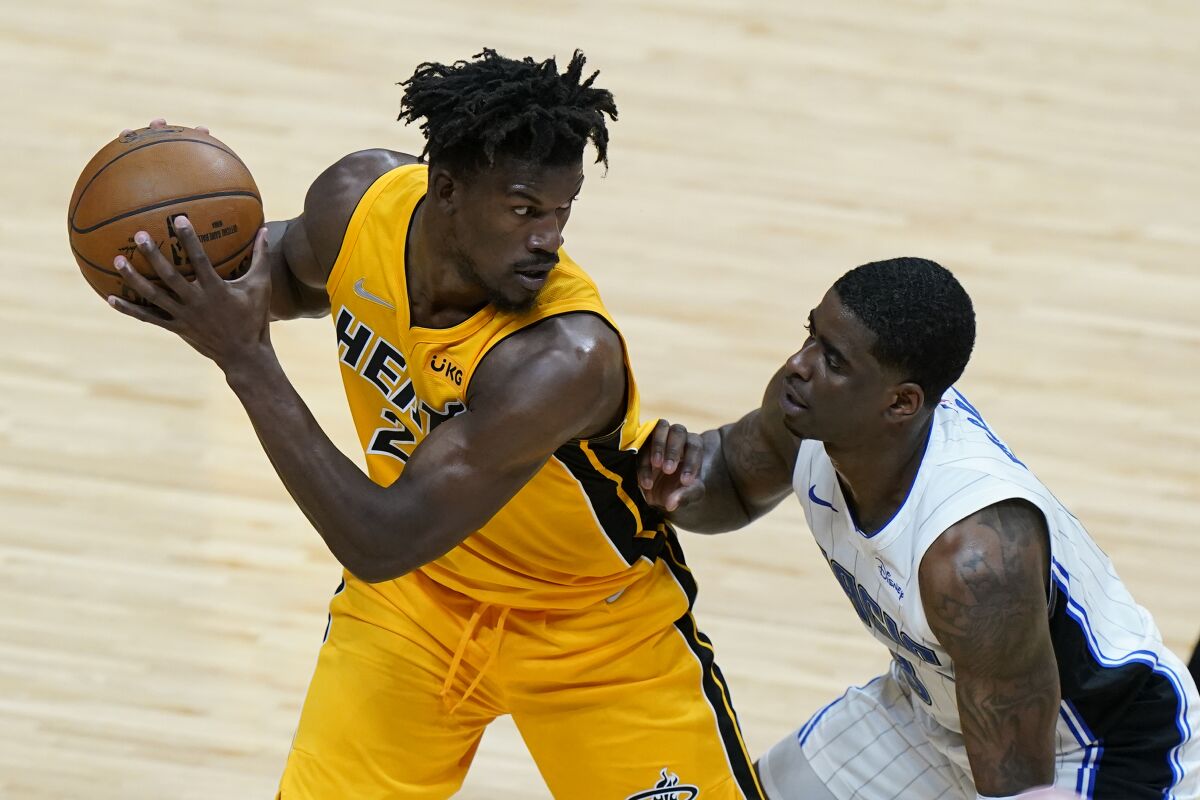 Miami Heat forward Jimmy Butler, left, looks for an opening past Orlando Magic guard Dwayne Bacon during the first half of an NBA basketball game, Thursday, March 11, 2021, in Miami. (AP Photo/Wilfredo Lee)