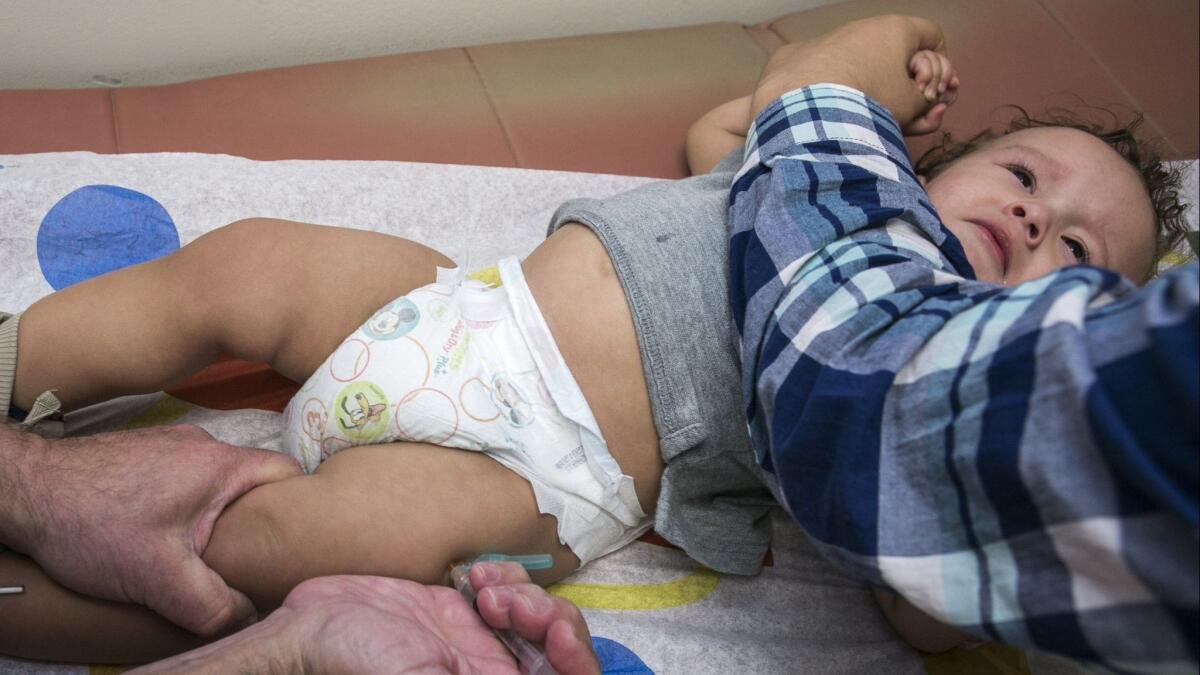 A pediatrician vaccinates an infant with the measles-mumps-rubella vaccine, or MMR vaccine, at his practice in Northridge, Calif. on Jan. 29, 2015.