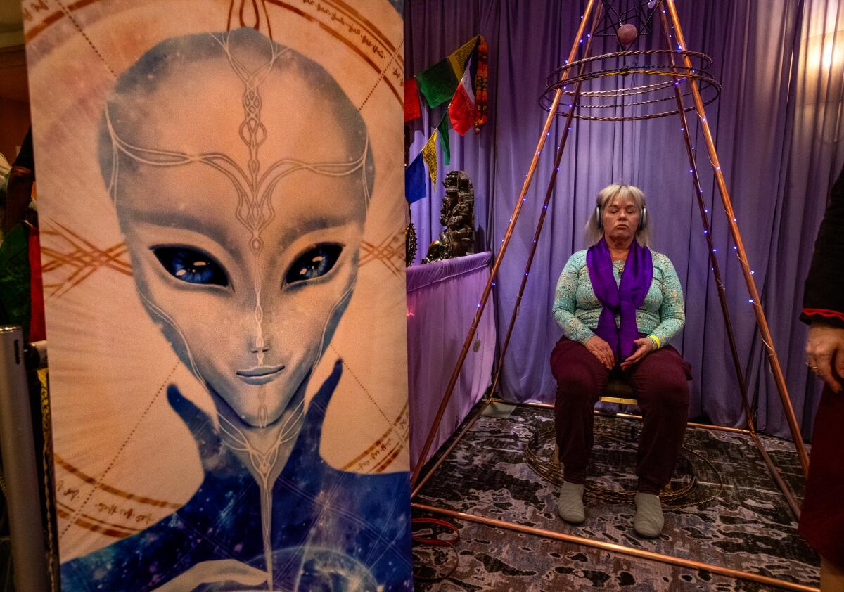 Carol Chappell sits inside a multi dimensional healing chamber enhanced by tensor rings at the Conscious Life Expo.