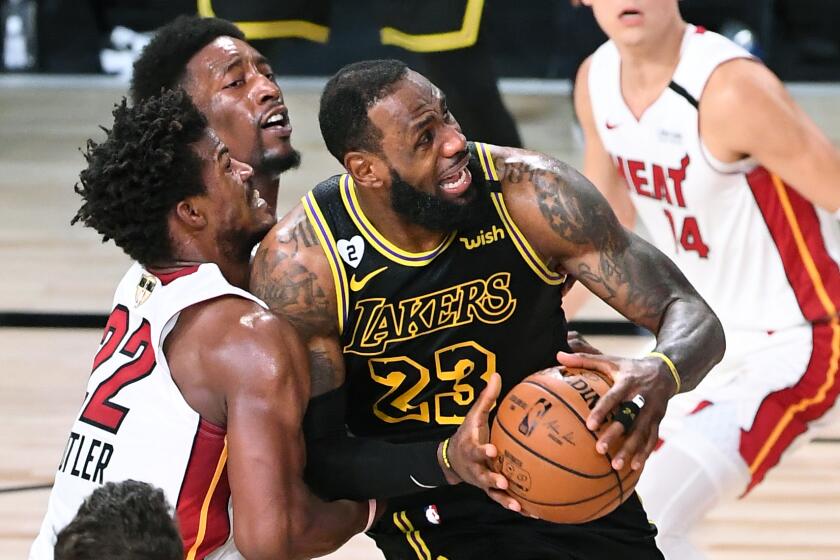 ORLANDO, FLORIDA OCTOBER 9, 2020-L:akers LeBron James is fouled by Heat's Jimmy Butler.