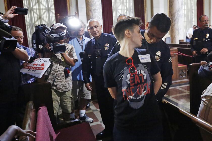 Sabrina Johnson is placed in handcuffs after being warned by LAPD Officers for refusing to leave after the Los Angeles City Council had a unanimous vote for a six-month extension of a law prohibiting people from sleeping in their cars.