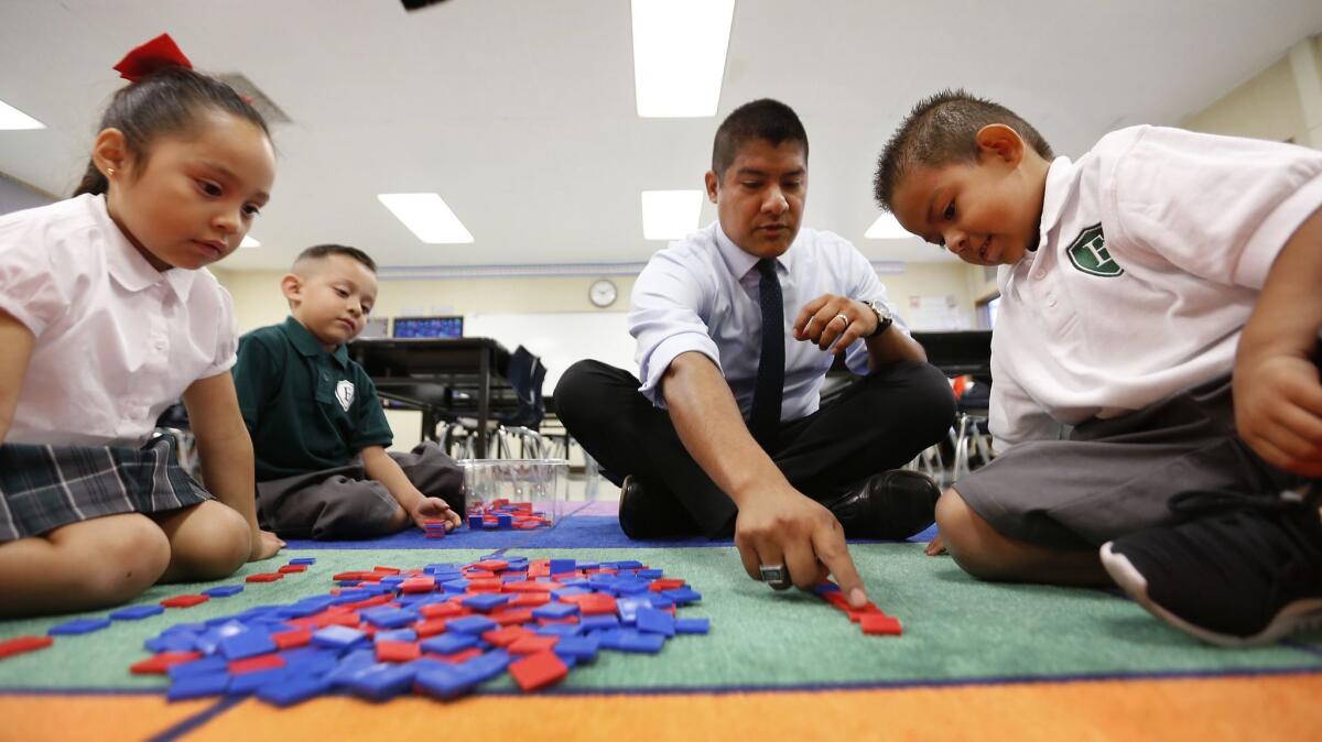 Excelencia Charter Academy founder Ruben Alonzo works with students at his new school, which shares a campus with Sunrise Elementary in Boyle Heights.