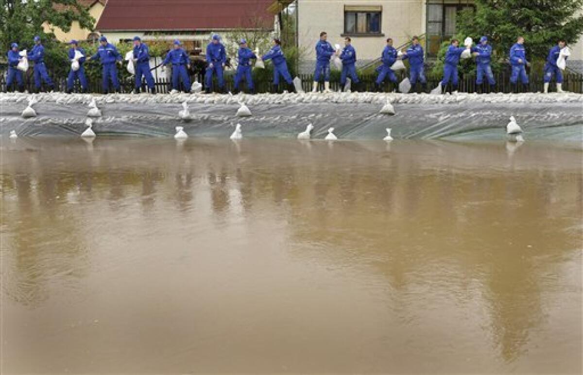 Police academy students load sandbags onto a broken dike to protect homes from flooding water in the village of Ocsanalos, northeastern Hungary, Tuesday, May 18, 2010. Several swollen rivers causing floods throughout Hungary, while roads remain closed due to the unusual wet weather and heavy rains.Heavy rains that began in central Europe last weekend also are causing flooding in areas of Poland , Slovakia and the Czech Republic, with rivers bursting their banks and inundating low-lying homes and roads, and cutting off villages. (AP Photo/Bela Szandelszky)