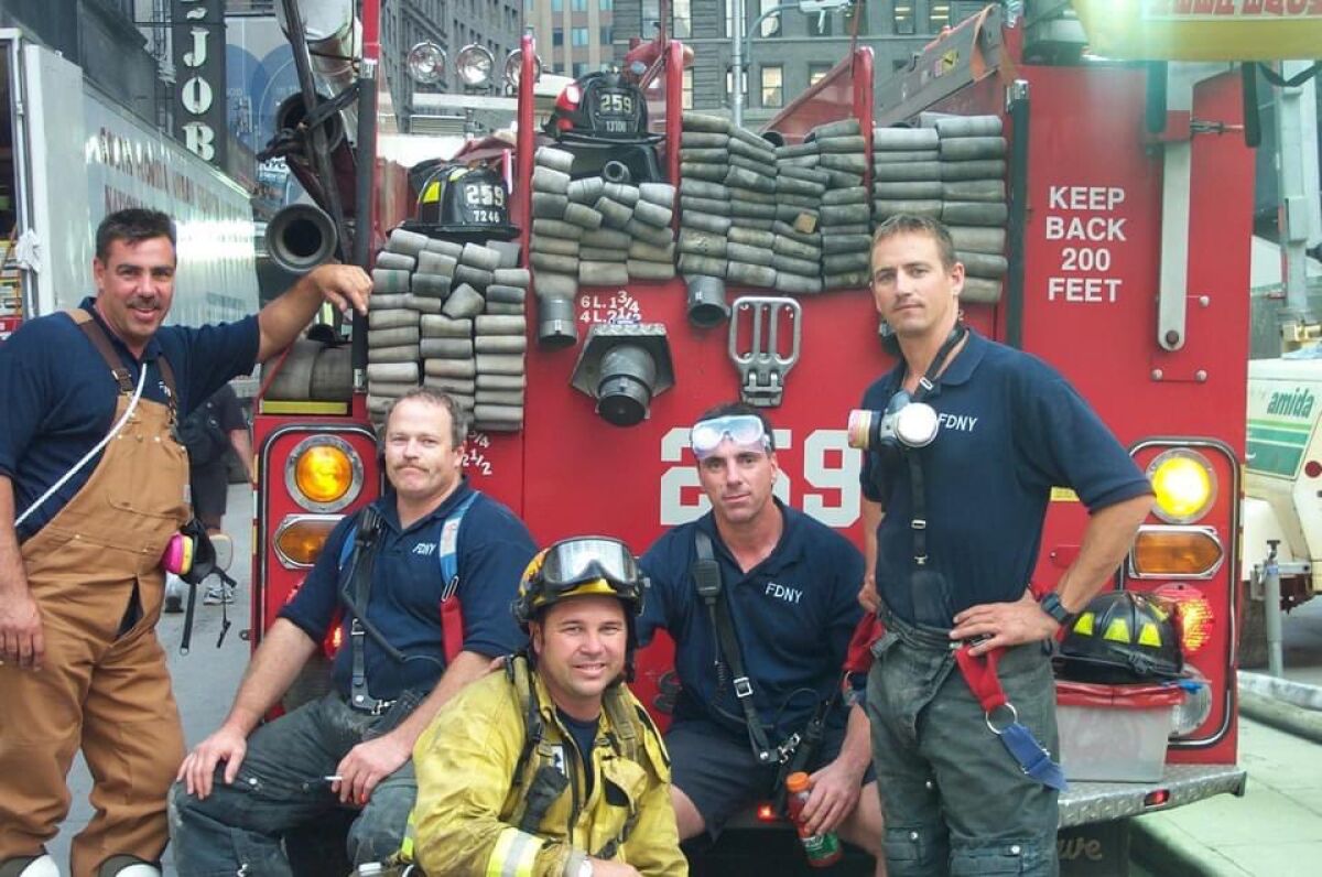 Rancho Santa Fe fire Capt. W. Chris Mertz, yellow jacket, poses with FDNY crews in 2001 while responding to 9/11.