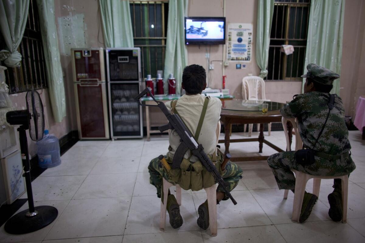 Kachin Independence Army soldiers watch TV at a restaurant in Laiza, Myanmar.