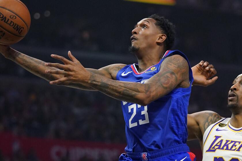 Los Angeles Clippers guard Lou Williams, left, shoots in front of Lakers center Dwight Howard.