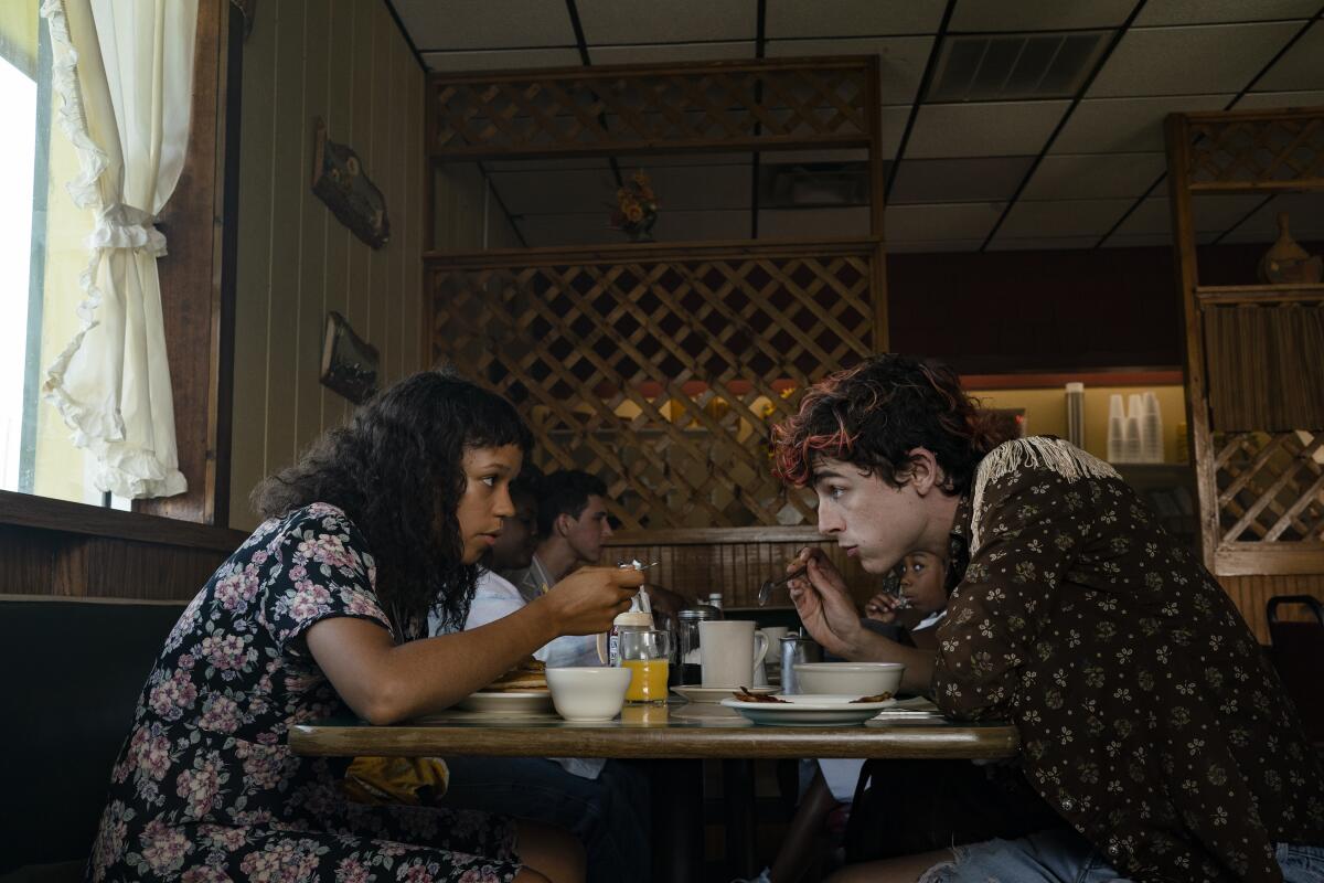 A woman, left, and a man sit across from each other at a table 