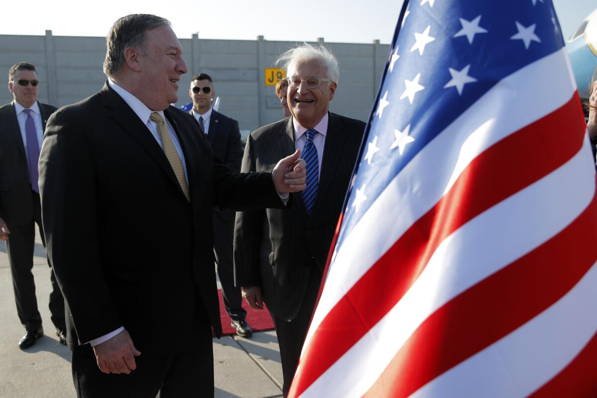Secretary of State Michael R. Pompeo, left, meets U.S. Ambassador to Israel David Friedman after landing in Tel Aviv in 2019