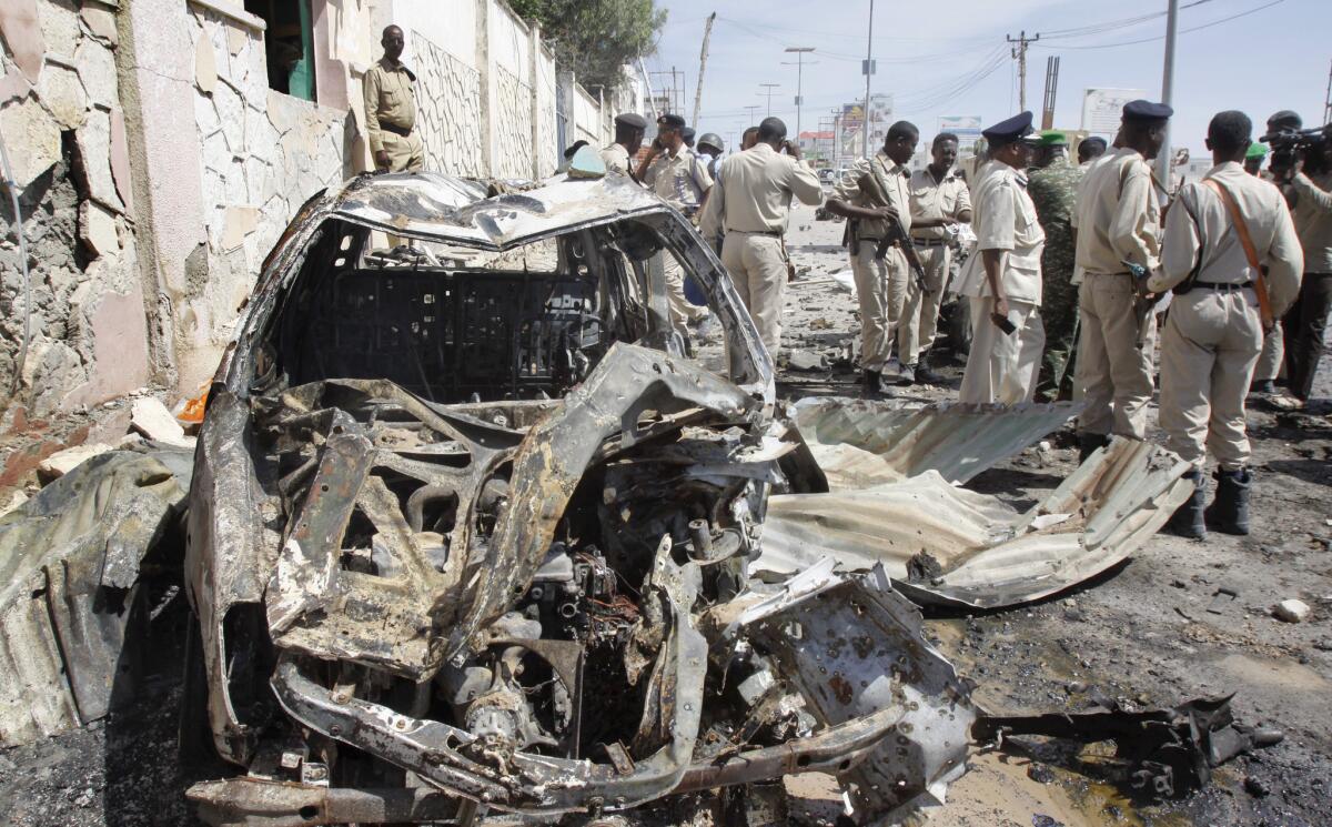 Somali soldiers stand by wreckage at the scene of a suicide bomb attack that targeted a U.N. convoy near the airport in Mogadishu on Dec. 3.