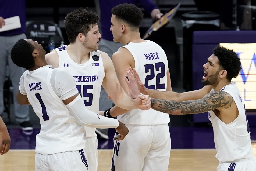 Northwestern center Ryan Young, second from left, celebrates with guard Chase Audige, left, and guard Boo Buie after scoring a basket against Nebraska during the second half of an NCAA college basketball game in Evanston, Ill., Sunday, March 7, 2021. (AP Photo/Nam Y. Huh)