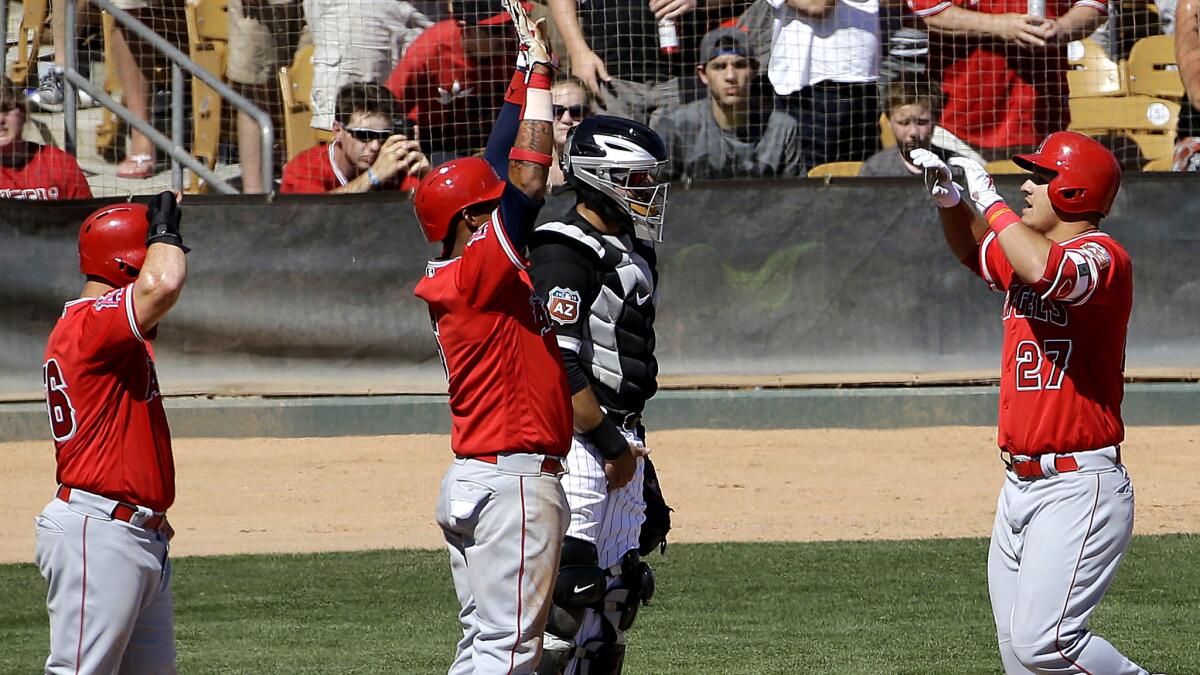 Angels center fielder Mike Trout, right, is congratulated after hitting a three-run home run that scored Kole Calhoun, left, and Yunel Escobar during the sixth inning Thursday against the White Sox.