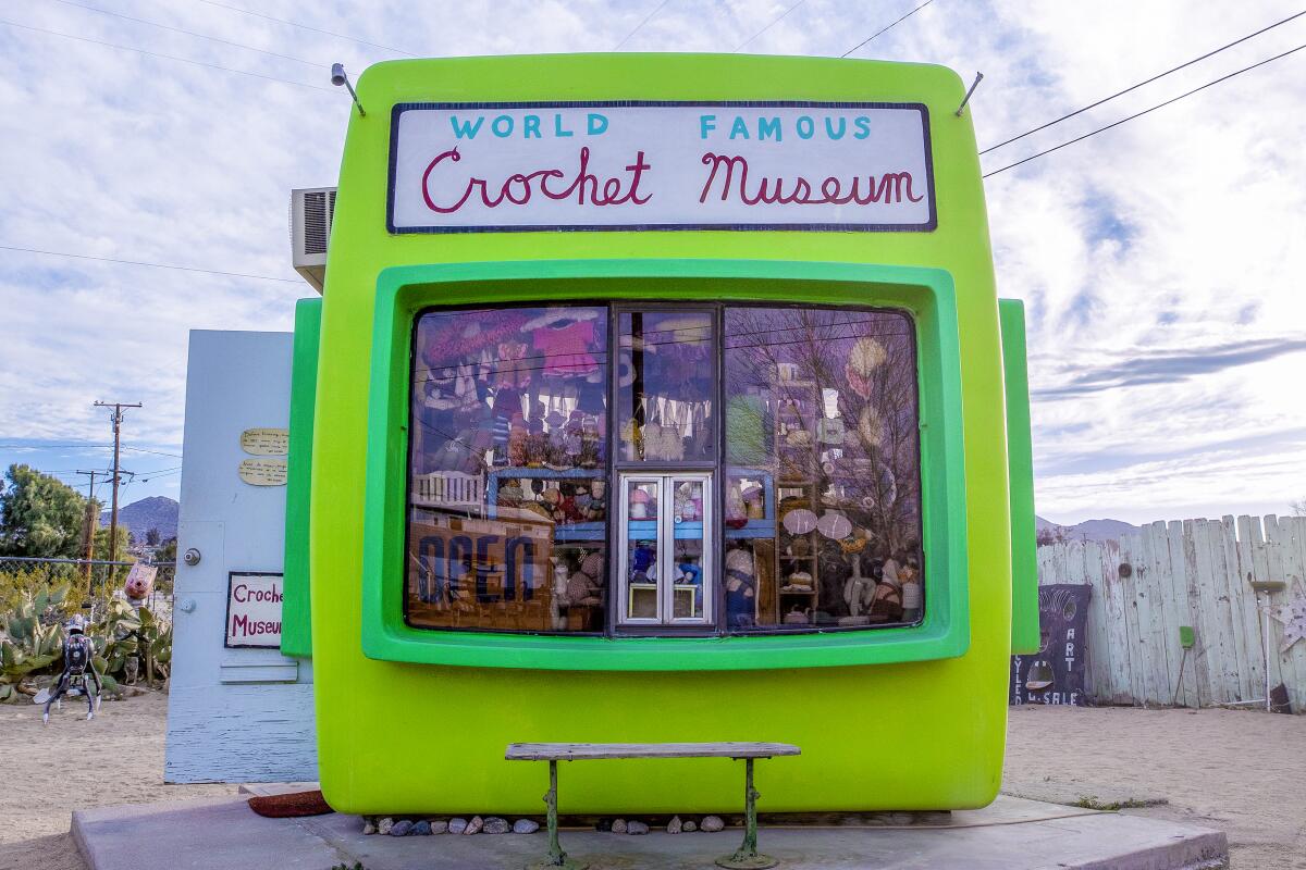 A square lime green building with a sign that reads "World Famous Crochet Museum."