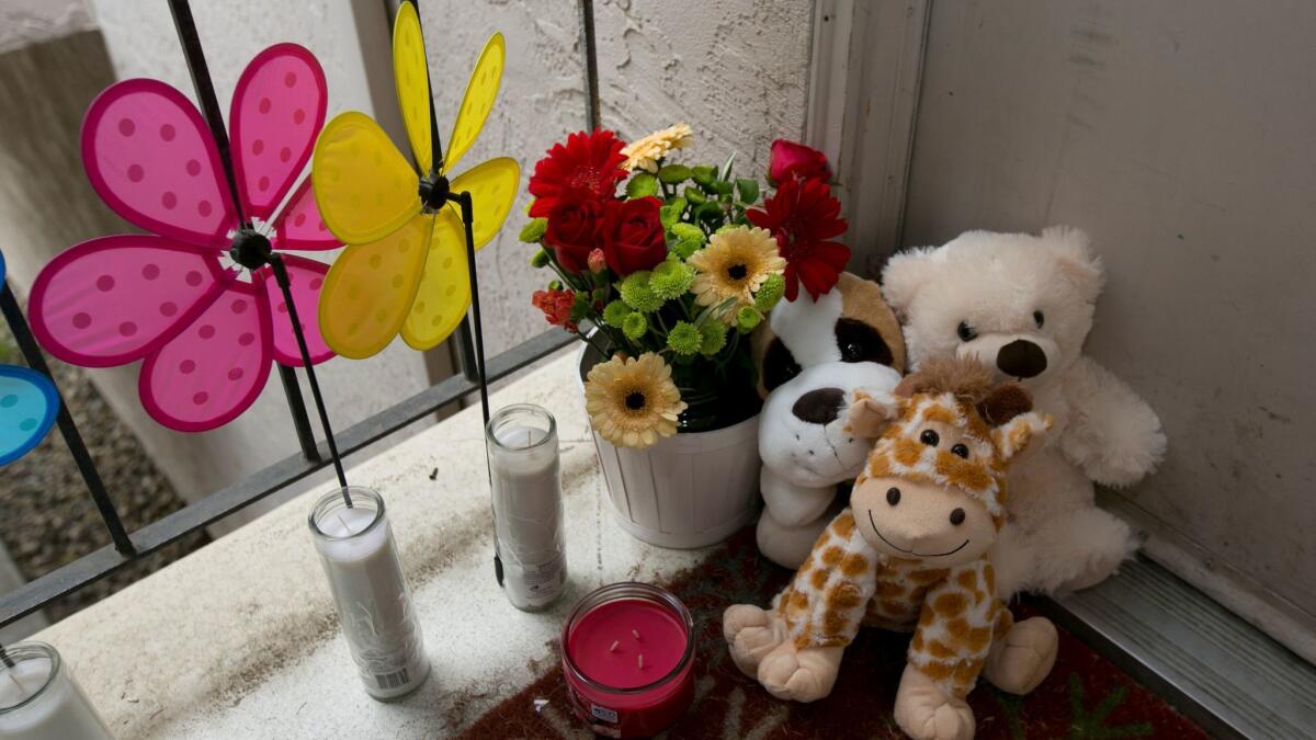 Candles and stuffed animals sit outside the West Sacramento apartment where three children were killed. Their father Robert Hodges, 33, has been arrested in the slayings.