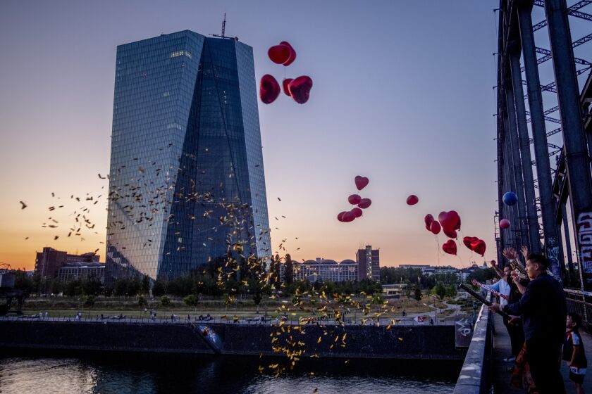 Relatives of a bridal couple let balloons fly from a bridge near the European Central Bank in Frankfurt, Germany, Wednesday, June 14, 2023. The governing council of the ECB will meet on Thursday. (AP Photo/Michael Probst)